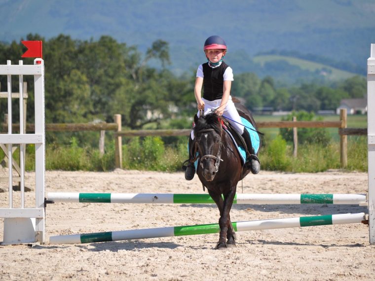 Anaë à cheval, les Pyrénées en fond